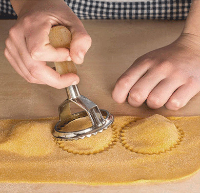Edelstahl-Ravioli-Form mit dem Holzgriff benutzt für die Herstellung von italienischen Mehlklößen